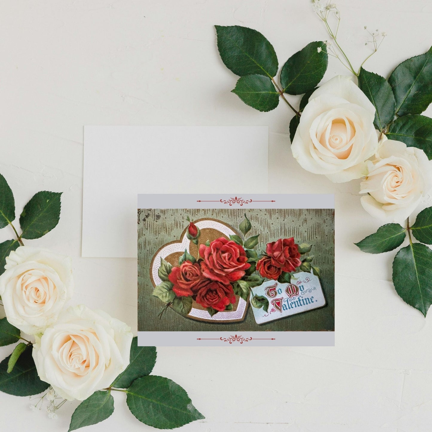 Valentine's Day card with red roses surrounded by white and green flowers on a light background